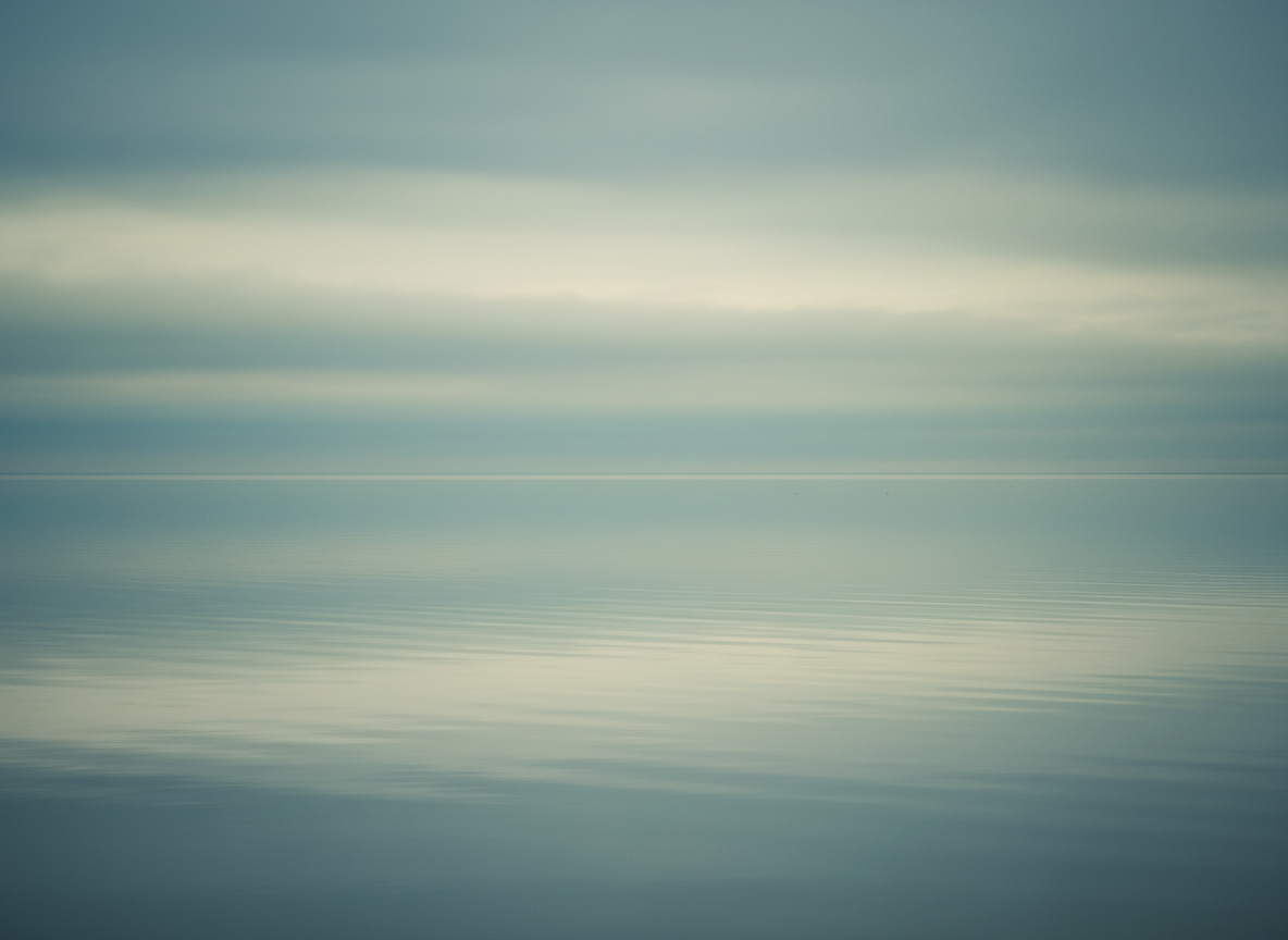 A calm abstract still water reflecting a soft overcast sky